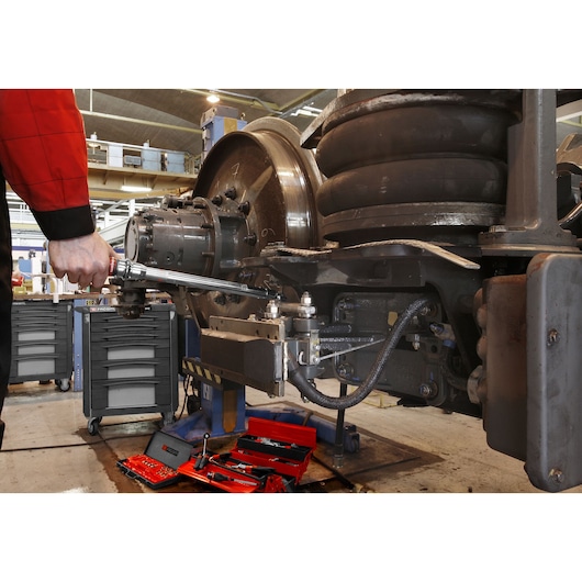 Facom S_306-100R torque wrench used on industrial machinery; red tool tray and wheeled tool cabinet visible.