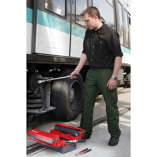 Facom S_306-350R red metal toolbox with assorted tools open next to a technician working on a train wheel.
