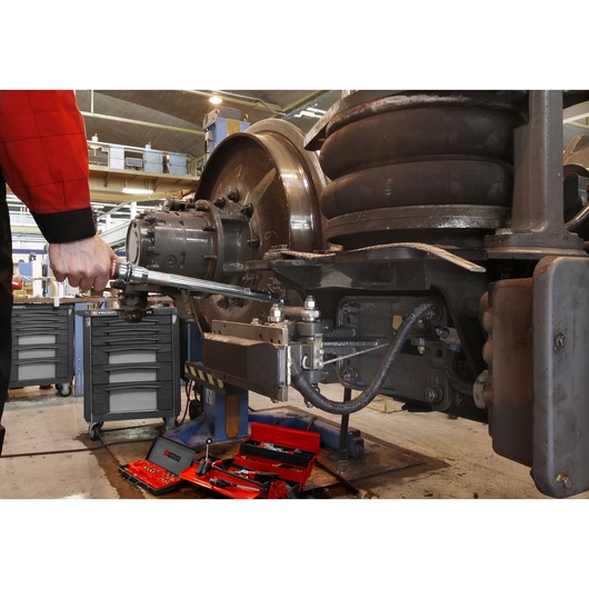 Facom S_306-350R torque wrench used on industrial machinery with red tool cases and drawers visible.
