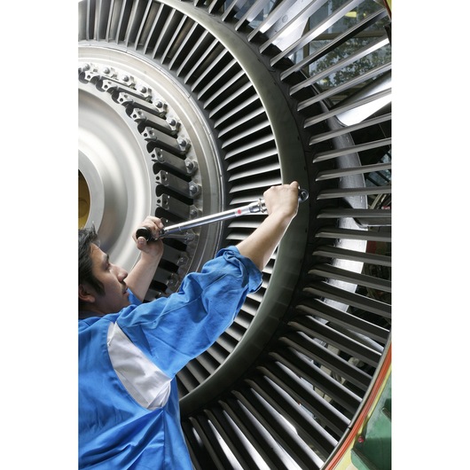 Facom S_306A350 torque wrench in use on industrial turbine, close-up side angle.