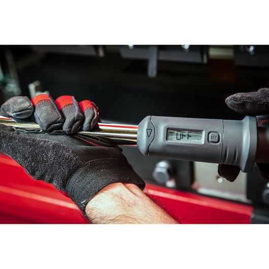 Facom digital torque wrench S.307-100D held by gloved hand, display screen showing 'OFF'.
