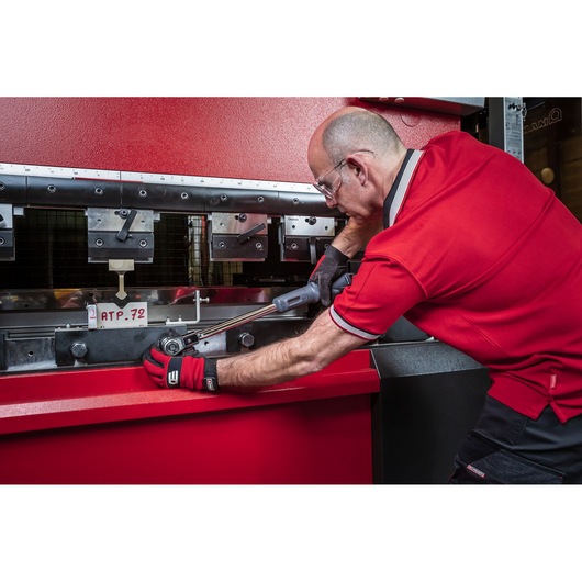 Facom S.307-340D torque wrench used by worker in red uniform and gloves on industrial machine.