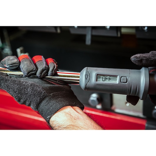 Facom digital torque wrench S.307A100, close-up held by gloved hands, LCD display showing OFF.