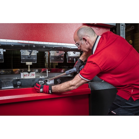 Facom S.307A200 torque wrench used by a worker in red on industrial machinery, side angle.