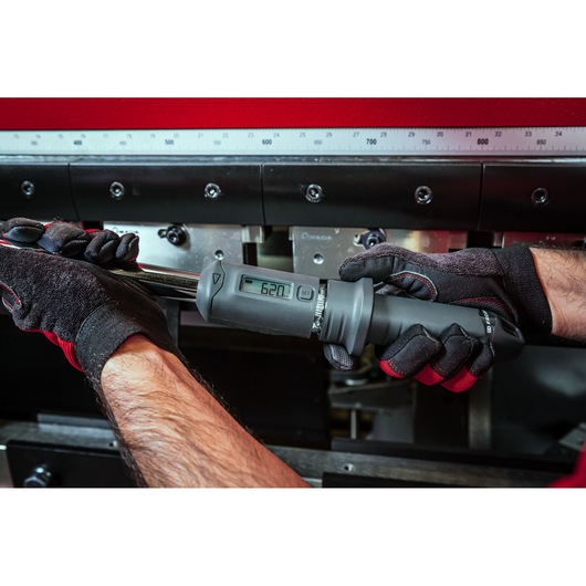 Photo of Facom S.307A200 digital torque wrench being used by gloved hands, clear digital display visible.