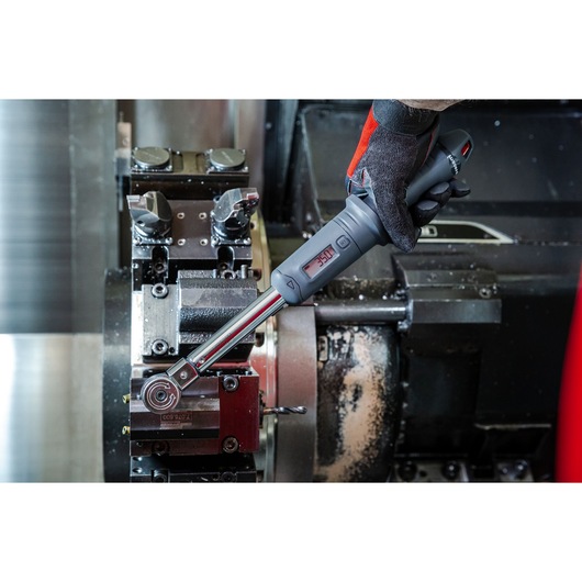 Facom S.307A340 digital torque wrench used on industrial machinery in workshop setting.