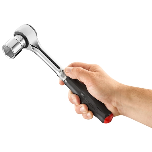 Photo of a Facom S_360 ratchet wrench with socket, black handle, held in a right hand, side angle.