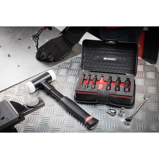 Facom SXE_J7MGRPPB mechanic bit set in open black case on metal workbench with tools and hammer.
