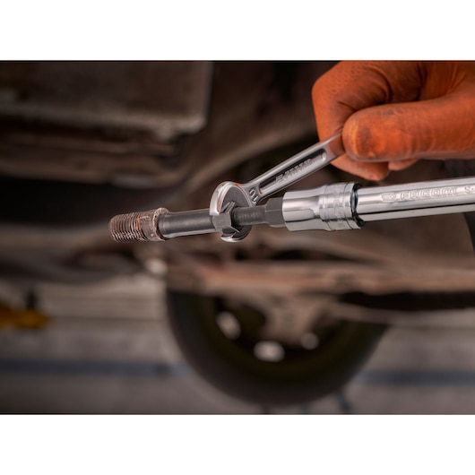 Facom SXE_J7MGRPPB wrench and socket tool in use on a threaded metal rod, close-up photography in workshop.