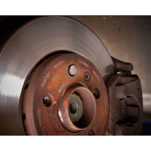 Facom SXE_J7MGRPPB close-up photo of rusty automotive brake disc with caliper