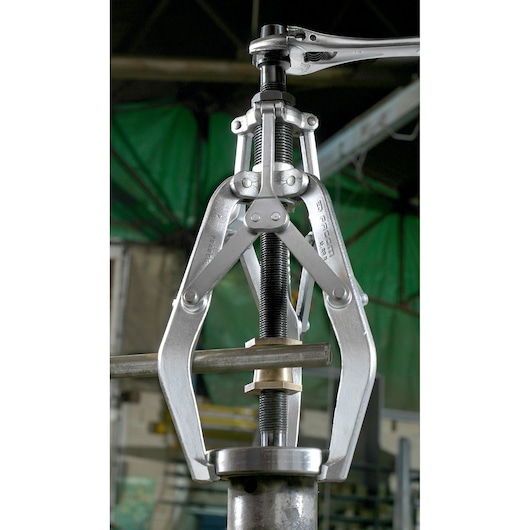 Facom U_20B three-jaw puller tool in use for mechanical part removal, photographed in industrial setting.