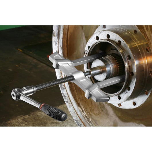 Facom U232J2PB bearing puller tool attached to industrial machinery shaft, detailed side view.