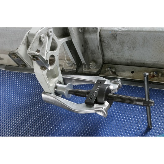 Facom U_301M puller tool mounted on an automotive part, shown in use on a textured blue mat.