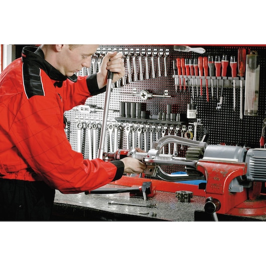 Facom U312H photography of worker using torque wrench in workshop with tools and red vise.