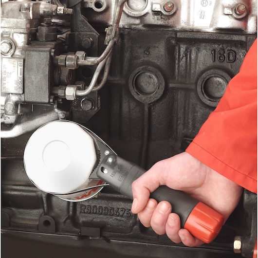 Facom U_46ACL oil filter wrench with black and red handle in use on engine component.