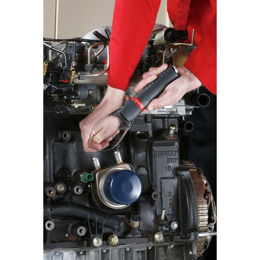 Facom U.48PB strap wrench being used on a car engine by a person in red uniform.