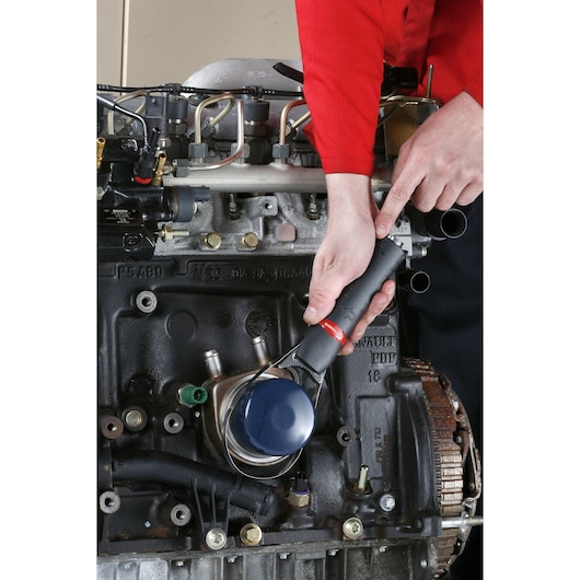 Facom U_48PL oil filter wrench in use on engine part, close-up view.