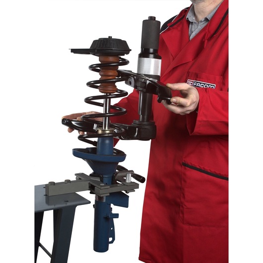 Facom U_89JMA spring compressor in use, front angle photography, technician in red coat.