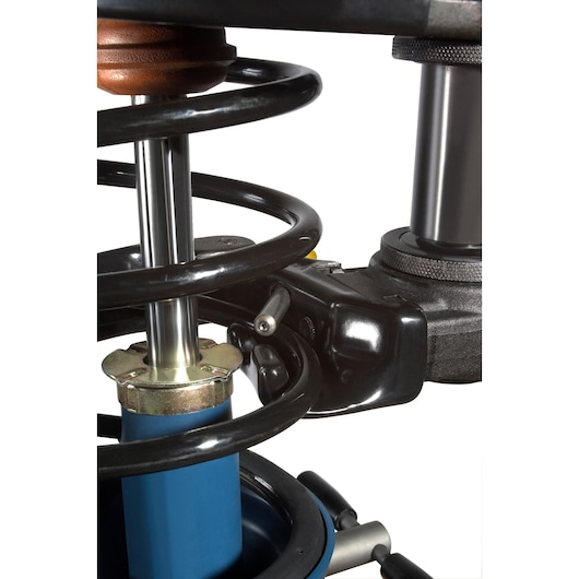 Facom U_89JMA photography of automotive spring compressor close-up, metal coil spring and blue cylinder visible.