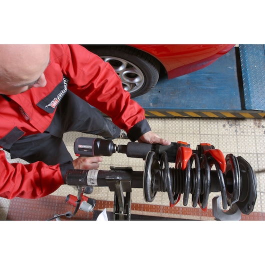 Facom U_89M230 photography of mechanic using tool on car suspension in workshop.