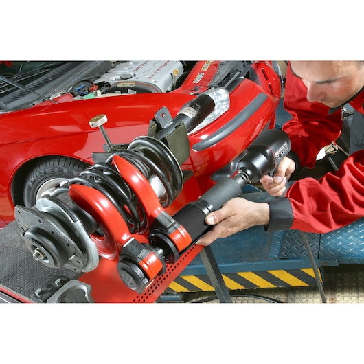 Facom U_89M230 automotive tool photo showing mechanic using tool on car suspension.