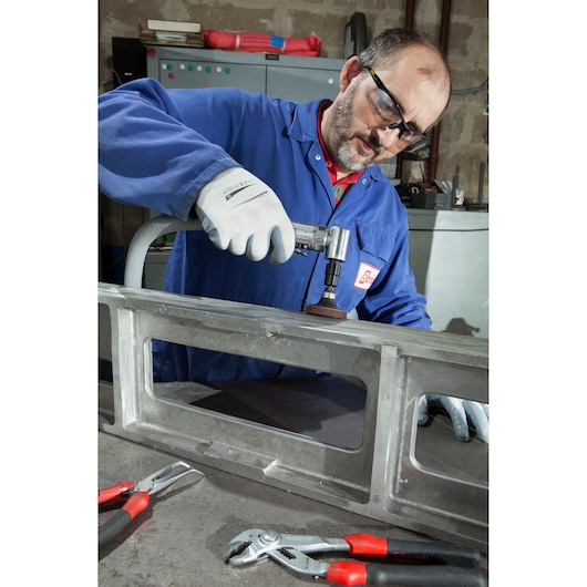Facom V_347F photography of worker using grinder, Facom pliers with red handles on workbench.