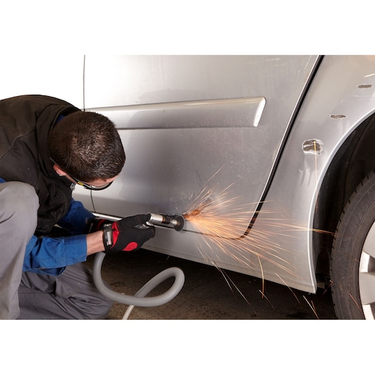 Facom V_347F pneumatic grinder in use on car body panel creating sparks during metalwork.
