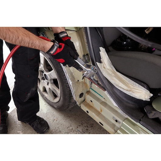 Facom V_402F pneumatic tool used on car bodywork, person wearing Facom gloves, close-up angle