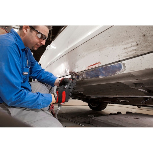 Facom V_445F pneumatic tool used for auto body repair by technician in blue uniform, workshop setting.