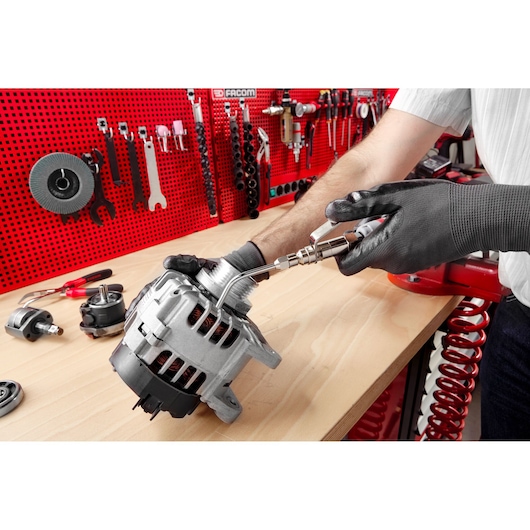 Facom V_999A auto part cleaning on workbench with air tool, red tool wall in background.