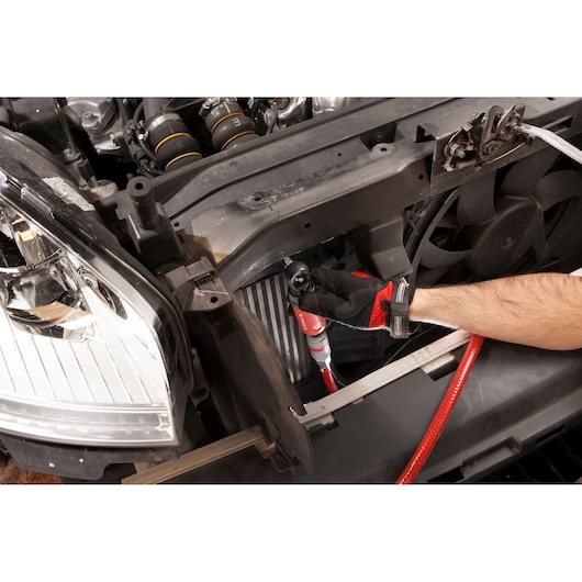 Facom VR.R127PB ratchet used on a car engine, close-up photography with red hose and gloves.
