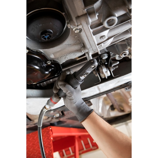 Facom VR_RJ2500PB ratchet tool in use under a vehicle, photographed in a workshop setting.