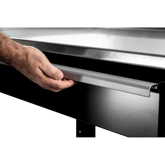 Photo of a hand opening a Facom WB2.1500GS workbench drawer, angled close-up on black metal surface.